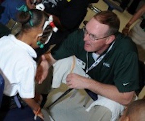 Coast Guard's Jason Southard helps kids get new shoes at Men's Basketball Final Four